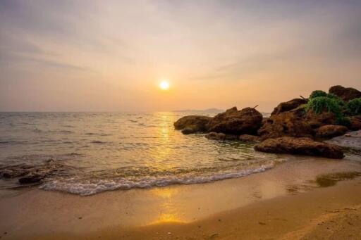 Sunset at the beach with rocks and calm waves