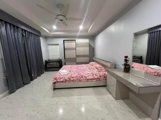 Modern bedroom with bed, wardrobe, dresser, and ceiling fan