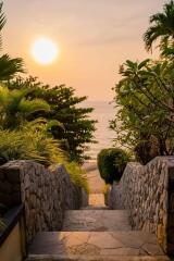 Stone pathway leading to a beach during sunset