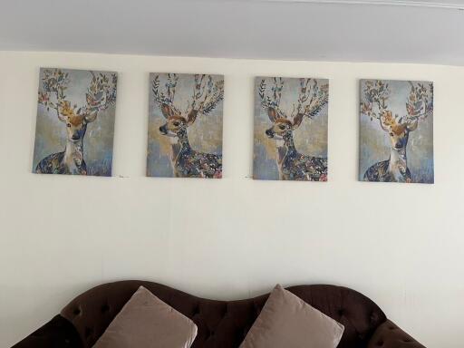 Living room with deer paintings and brown sofa