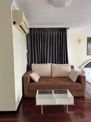 Living room with sofa, coffee table, and air conditioner