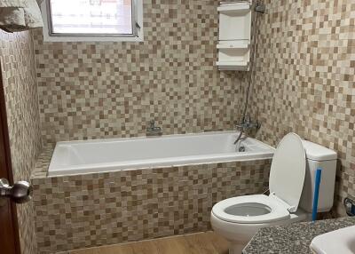 Bathroom with bathtub and tiled walls