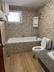 Bathroom with bathtub and tiled walls