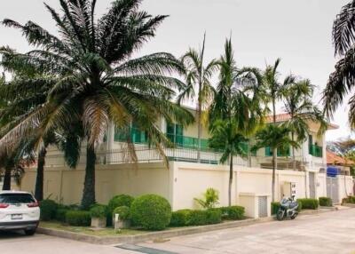 Exterior view of a two-story building with tropical landscaping