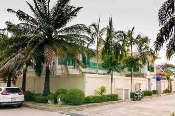 Exterior view of a two-story building with tropical landscaping