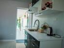 Modern kitchen with white countertops and cabinets, featuring appliances and decorations.