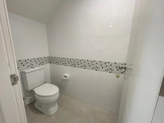 Modern bathroom with white tile walls and a mosaic tile border