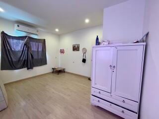 Simple bedroom with wooden flooring and basic furniture