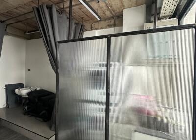 Modern bathroom with industrial ceiling and frosted glass partition