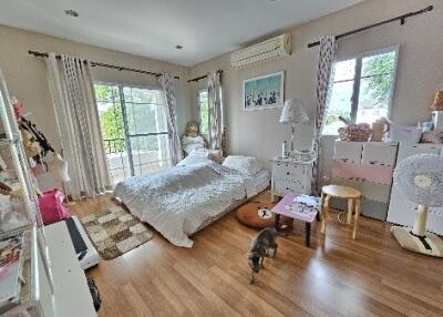 Spacious bedroom with hardwood floors, a double bed, and a balcony view