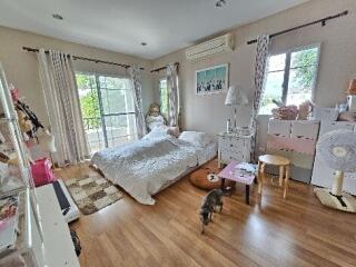 Spacious bedroom with hardwood floors, a double bed, and a balcony view