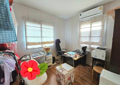 Bedroom converted into a workspace with office equipment and storage