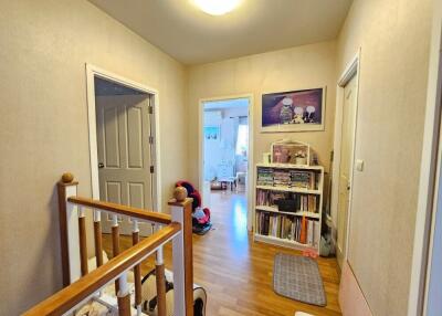 Well-lit hallway with wooden flooring and access to multiple rooms