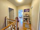 Well-lit hallway with wooden flooring and access to multiple rooms