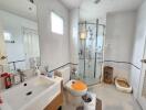 Modern bathroom with glass shower, sink, toilet, and window