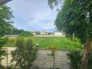 View of backyard with lush green foliage and neighboring houses