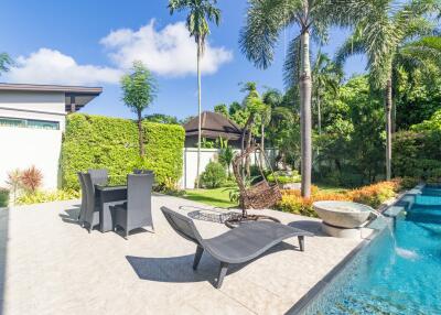 Spacious backyard with pool, greenery, and seating area