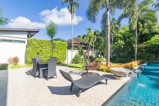 Spacious backyard with pool, greenery, and seating area