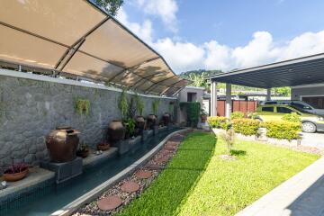 Outdoor garden with water feature and carport