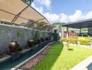 Outdoor garden with water feature and carport