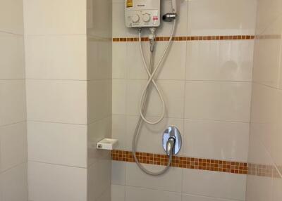 Bathroom shower area with water heater