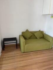 Cozy living room with green couch and wooden floor