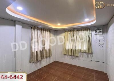 small room with decorative ceiling and curtains