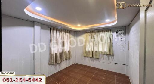 small room with decorative ceiling and curtains