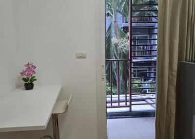 Small bedroom with desk, chair, and window overlooking a garden