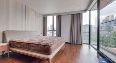 Spacious bedroom with city view and wooden flooring