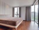 Spacious bedroom with city view and wooden flooring