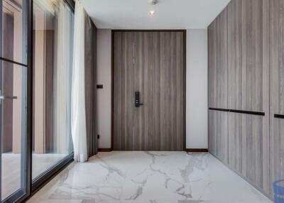 Modern apartment entrance with wooden door and marble floor