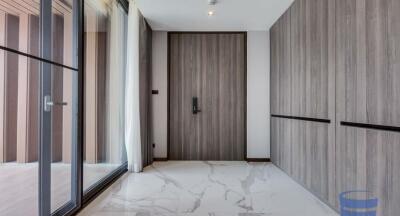 Modern apartment entrance with wooden door and marble floor