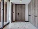 Modern apartment entrance with wooden door and marble floor