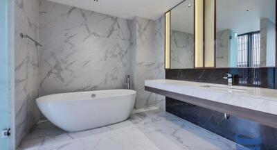 Modern bathroom with marble walls and freestanding bathtub