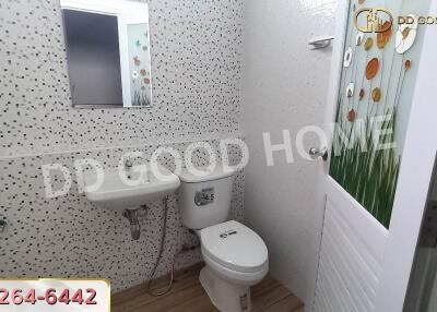 Modern bathroom with patterned tiles, sink, toilet, and decorative door