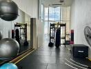 Modern gym with fitness equipment and large windows