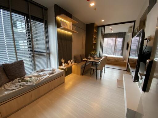 Modern living area with dining space leading to a bedroom