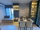 Modern dining area with a table set for four adjacent to a cozy window seat and decorative shelving