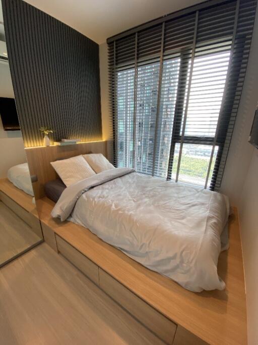 Modern bedroom with large window and blinds