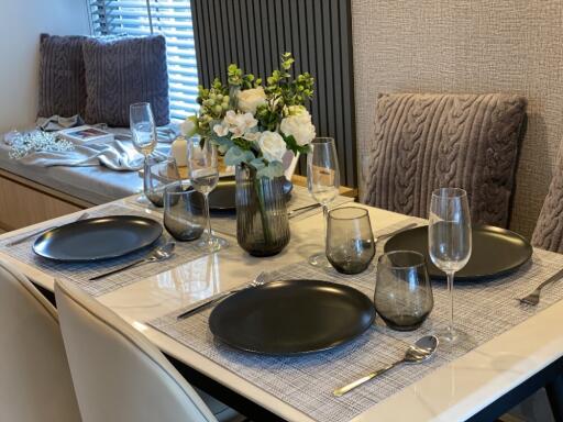 Elegantly set dining table with black plates and wine glasses