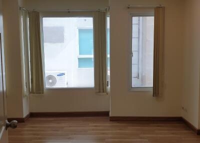 Empty room with wooden floor and large windows