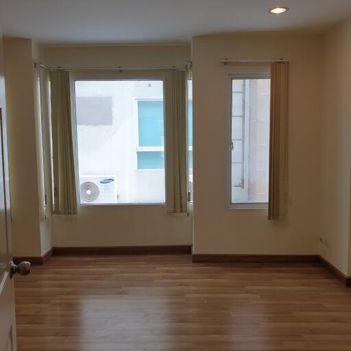 Empty room with wooden floor and large windows