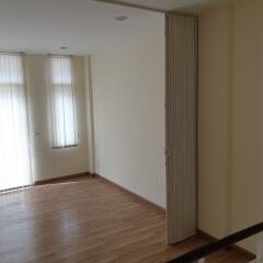 Empty living room with wooden floor and natural light