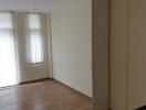 Empty living room with wooden floor and natural light