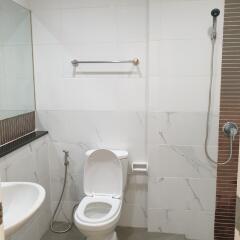 Modern bathroom with toilet, sink, shower, and towel rail