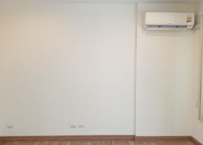 Empty living room with hardwood floor and air conditioner