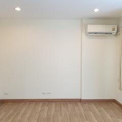 Empty living room with hardwood floor and air conditioner