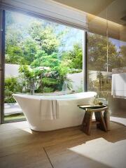 Modern bathroom with a freestanding bathtub next to a large window with a garden view