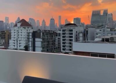 Rooftop balcony with a city skyline view during sunset